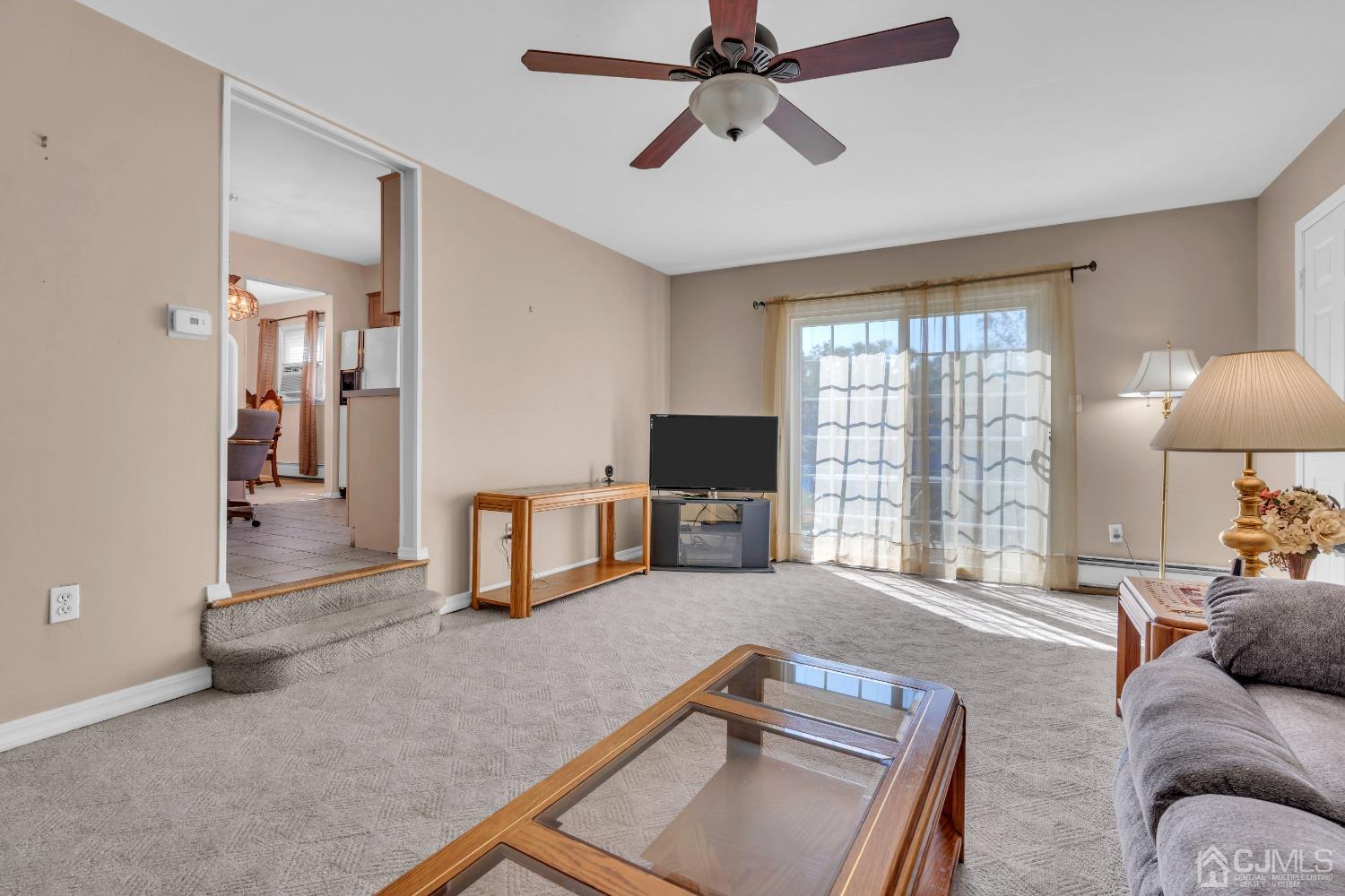 1 Robinhood Drive Sayreville, NJ 08859 - Photo 9 of 29 a living room with furniture a flat screen tv and a large window