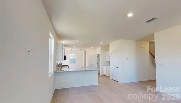 a view of a kitchen with kitchen island white cabinets and refrigerator