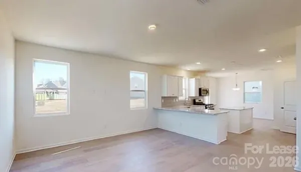 a kitchen with stainless steel appliances kitchen island sink refrigerator and window
