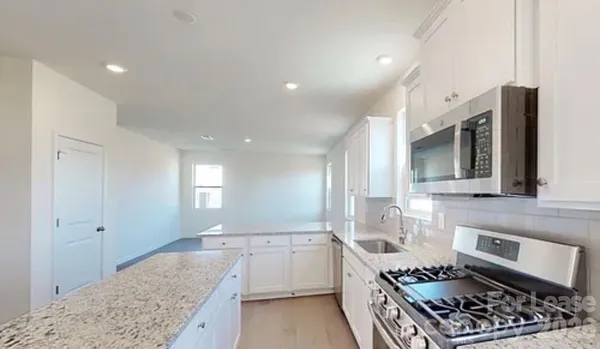 a kitchen with stainless steel appliances granite countertop a stove and a sink