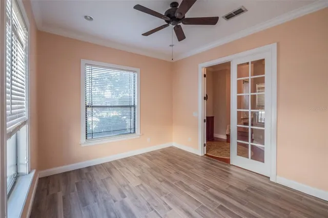 an empty room with wooden floor and windows