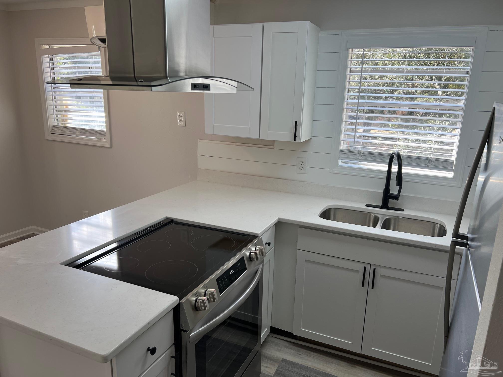 6642 Applegate Street Milton, FL 32570 - Photo 7 of 10 a kitchen with granite countertop a sink a stove and cabinets