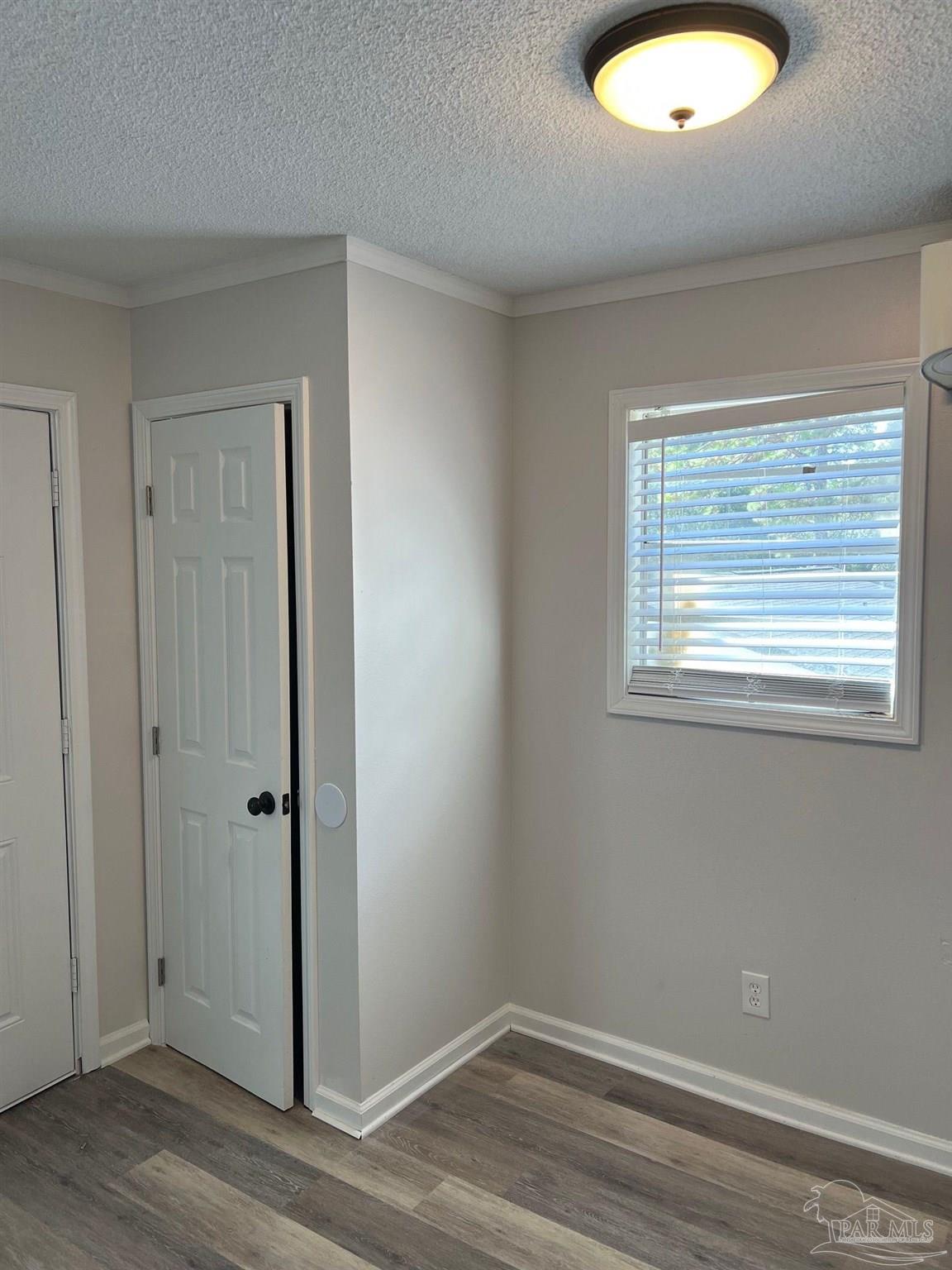 6642 Applegate Street Milton, FL 32570 - Photo 8 of 10 an empty room with wooden floor and windows