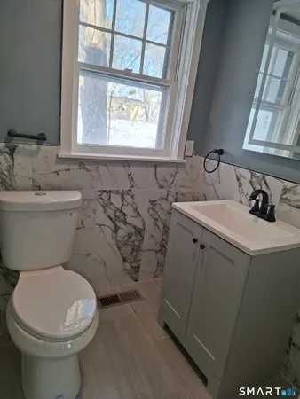 a bathroom with a sink toilet and window