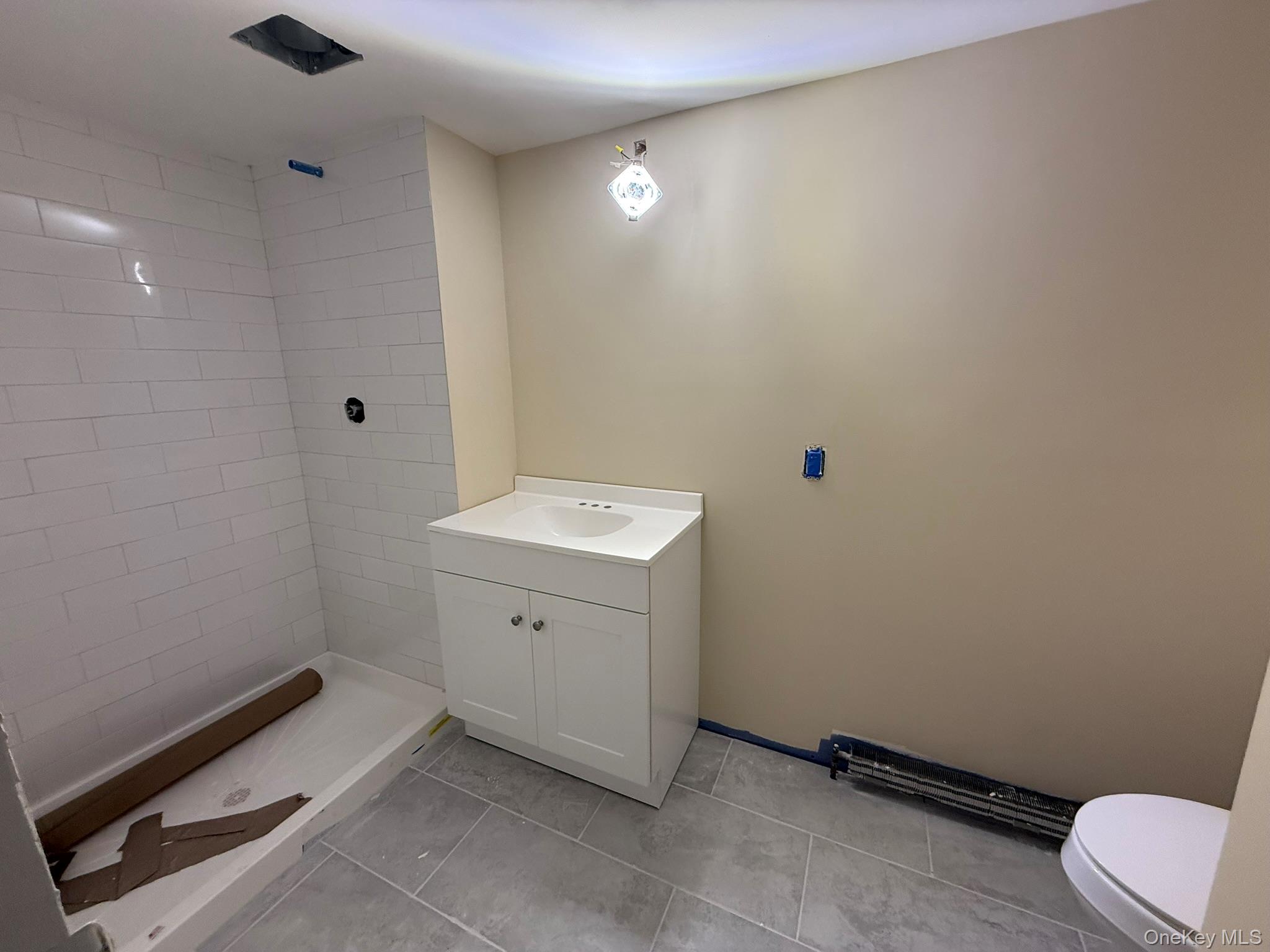 24 Poplar Place Bay Shore, NY 11706 - Photo 2 of 10 Full bath with vanity, a shower stall, and light tile patterned floors