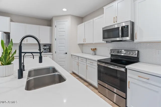 a kitchen with sink a microwave and cabinets
