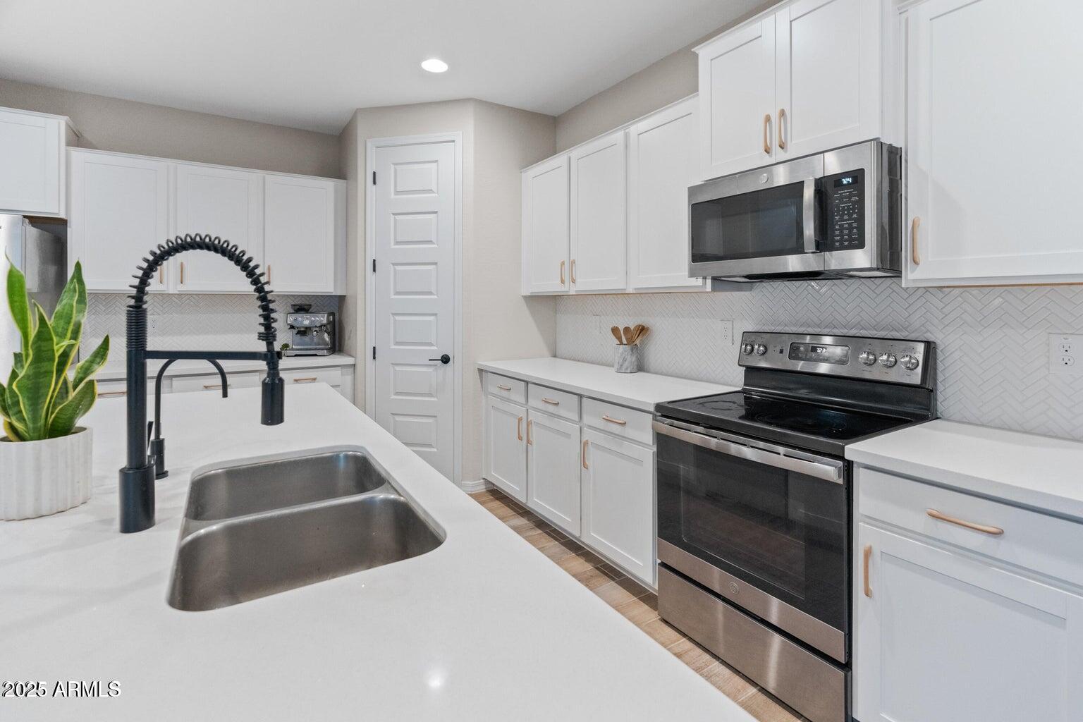 14274 West Sand Hills Road Surprise, AZ 85387 - Photo 16 of 24 a kitchen with sink a microwave and cabinets
