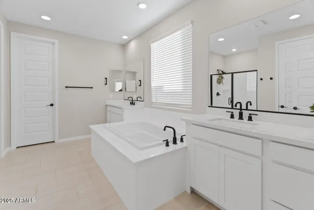 a bathroom with a sink a tub and a mirror