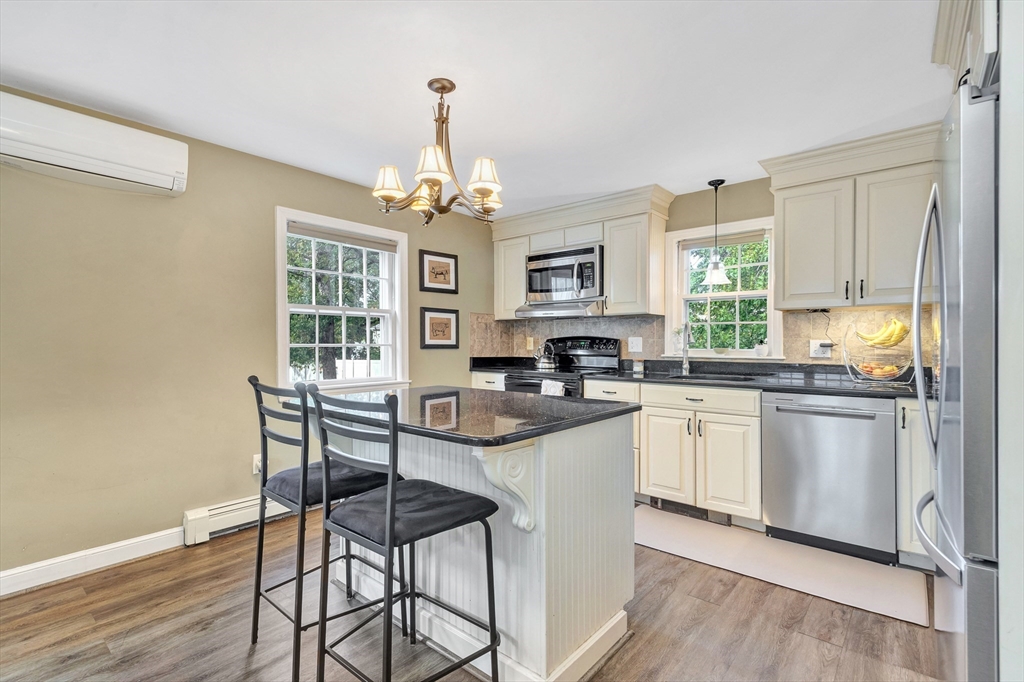 14 Hanson Street Dedham, MA 02026 - Photo 20 of 41 a kitchen with stainless steel appliances granite countertop a stove top oven a refrigerator a sink and dishwasher with wooden floor