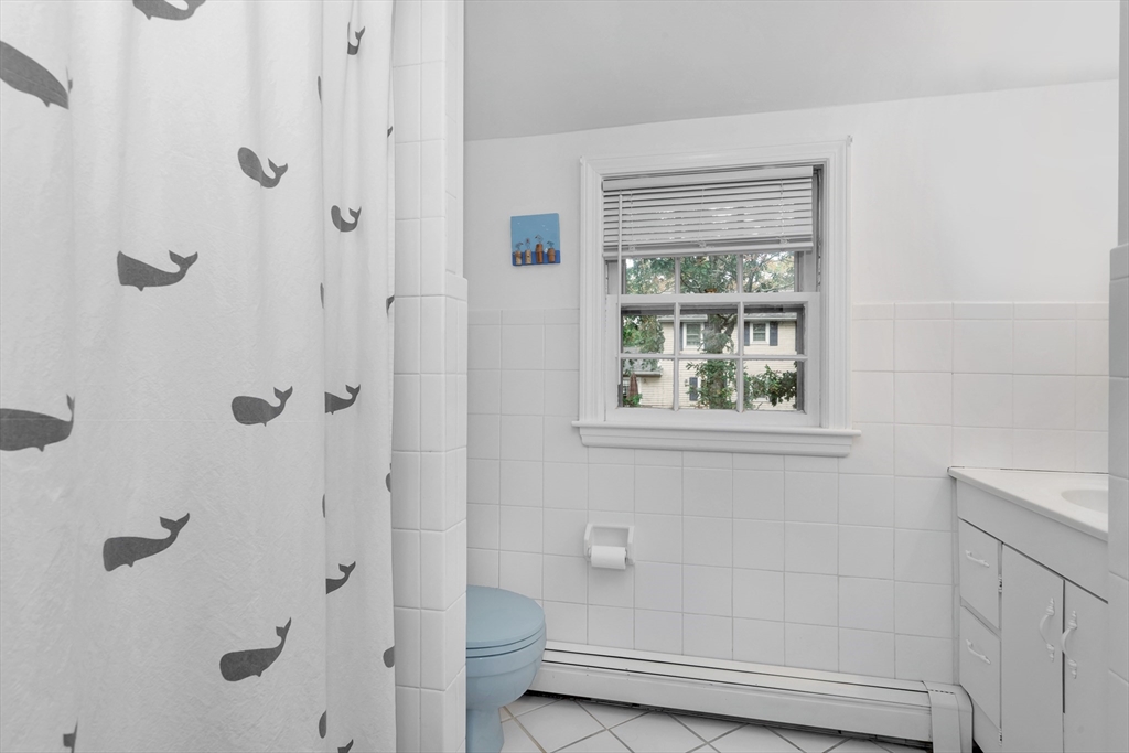 14 Hanson Street Dedham, MA 02026 - Photo 36 of 41 a bathroom with a granite countertop bathtub next to a window