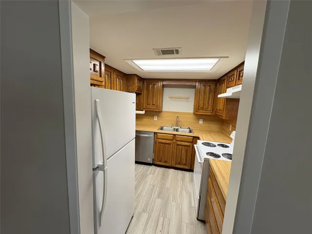 a kitchen with a refrigerator a sink and a stove