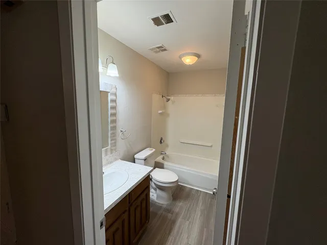 a bathroom with a granite countertop toilet a sink and a mirror