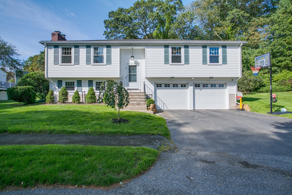 a front view of a house with a yard and trees