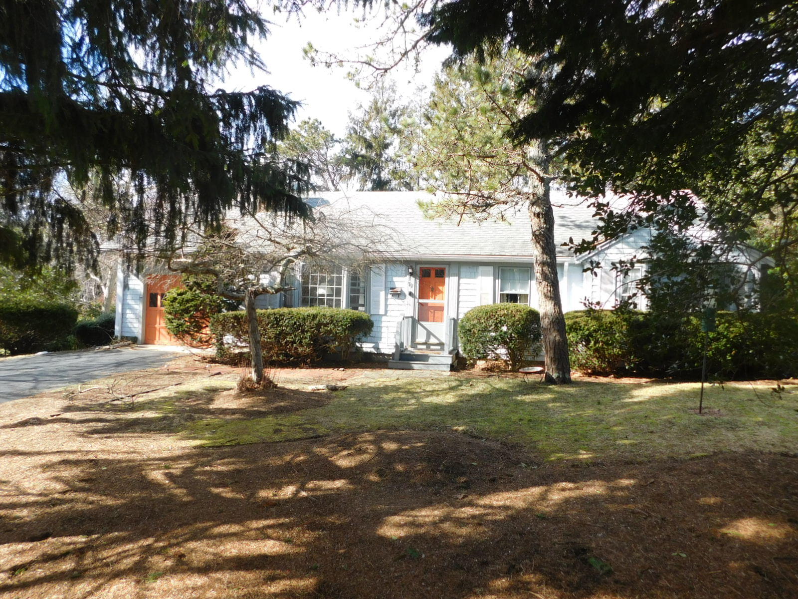 79 Joan Road Centerville, MA 02632 - Photo 2 of 4 a front view of a house with a yard garage and outdoor seating