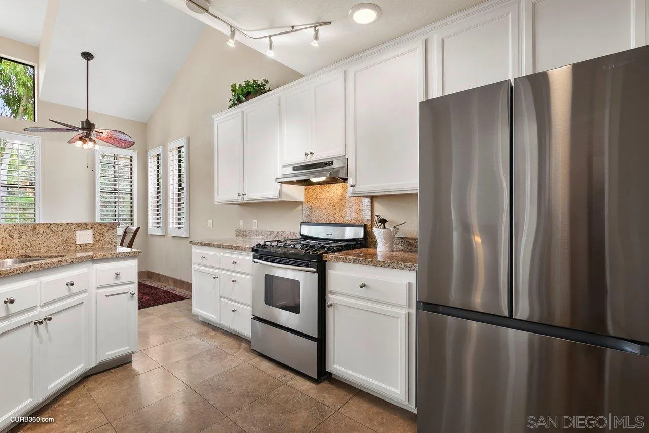 4579 54th Street San Diego, CA 92115 - Photo 9 of 39 a kitchen with stainless steel appliances a refrigerator sink and cabinets