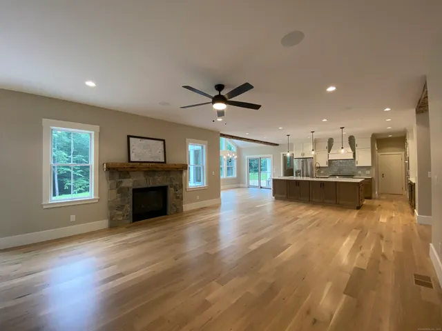 a view of an empty room with a kitchen and a window