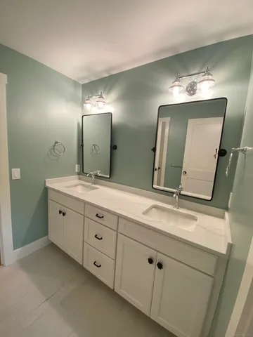 a bathroom with a double vanity sink and a mirror