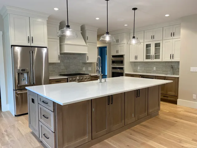a kitchen with kitchen island a counter space a sink stainless steel appliances and cabinets