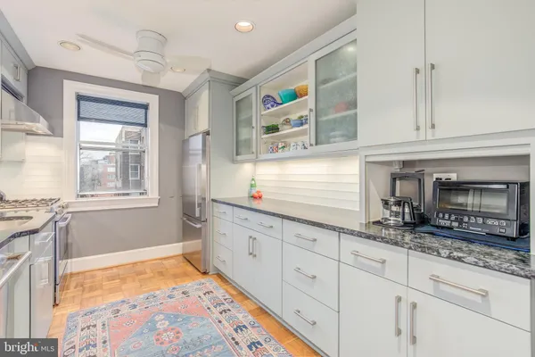 a kitchen with granite countertop cabinets stainless steel appliances a sink and a window