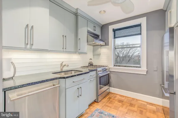 a kitchen with granite countertop cabinets sink and window