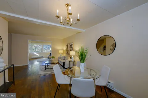 a living room with dining table and a chandelier