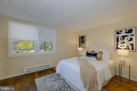a bedroom with a bed and painting on the wall