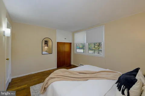 a bedroom with a bed and a painting on the wall