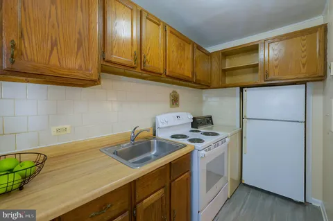 a kitchen with stainless steel appliances granite countertop a sink a stove cabinets and wooden floor