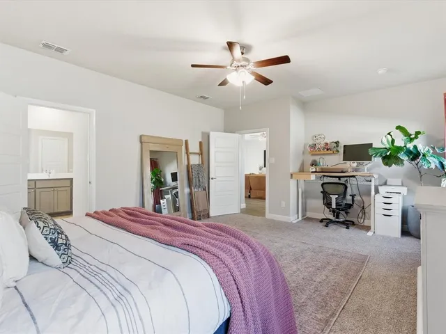 a bedroom with a large bed and a chandelier