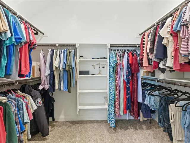 a view of walk in closet with clothes