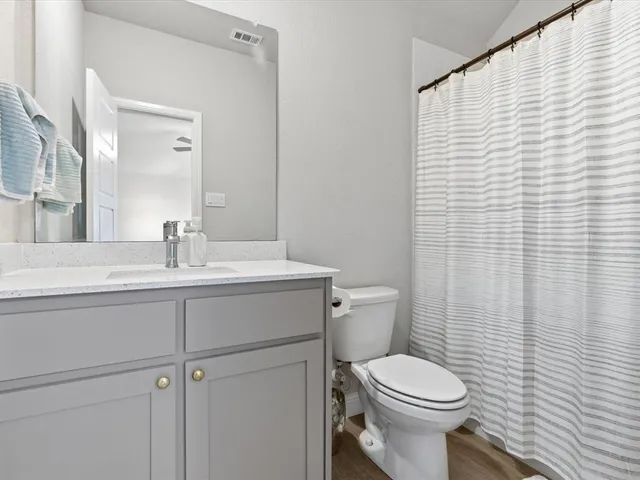 a bathroom with a sink a toilet and a mirror