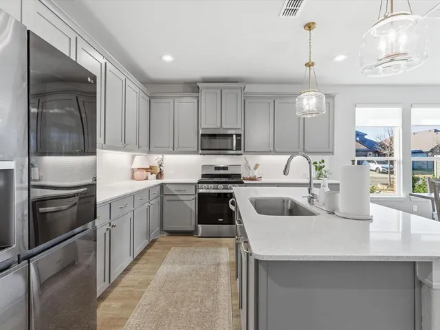 a kitchen with white cabinets and stainless steel appliances