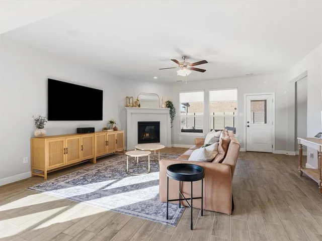 a living room with furniture a flat screen tv and a fireplace