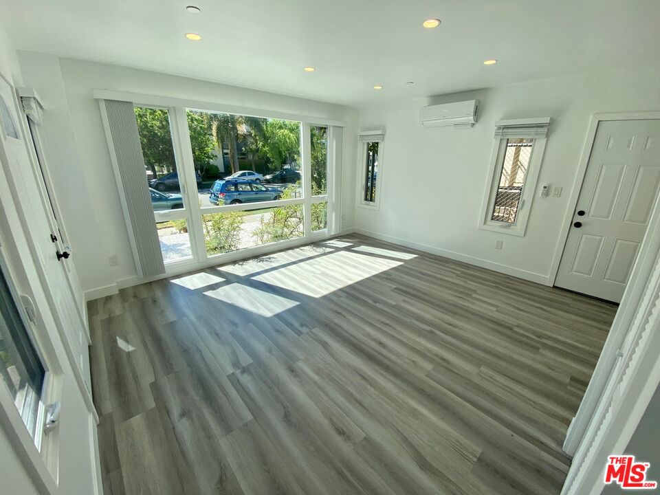 1217 9th Street, Unit 1 Santa Monica, CA 90401 - Photo 13 of 21 a view of an empty room with wooden floor and a window
