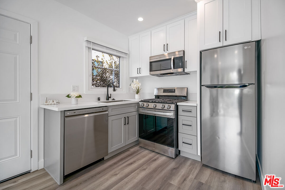 1217 9th Street, Unit 1 Santa Monica, CA 90401 - Photo 16 of 21 a kitchen with stainless steel appliances a refrigerator sink and microwave