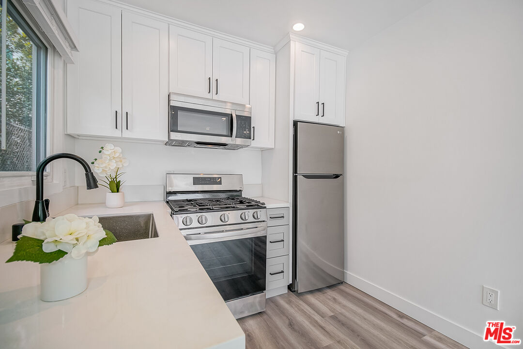 1217 9th Street, Unit 1 Santa Monica, CA 90401 - Photo 17 of 21 a kitchen with a microwave a stove and a refrigerator