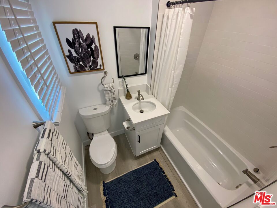 1217 9th Street, Unit 1 Santa Monica, CA 90401 - Photo 18 of 21 a bathroom with a toilet a sink and mirror