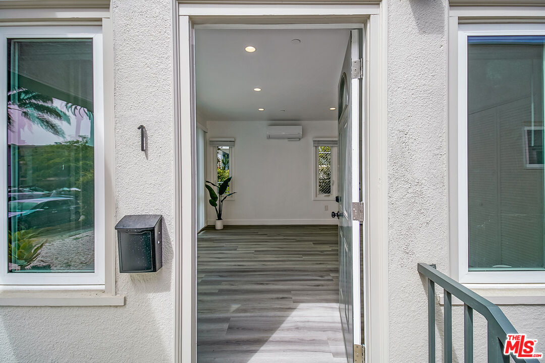 1217 9th Street, Unit 1 Santa Monica, CA 90401 - Photo 4 of 21 a view of a hallway with wooden floor and a living room