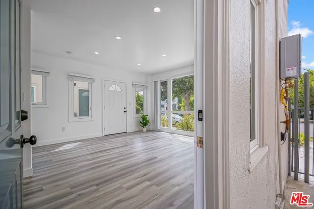 a view of a hallway with wooden floor and an entryway