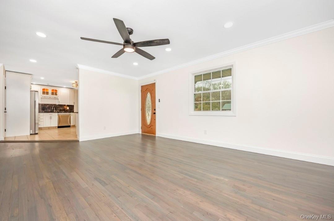 59 Nelson Road Selden, NY 11784 - Photo 12 of 38 Unfurnished living room featuring light wood-style floors, ornamental molding, ceiling fan, and recessed lighting