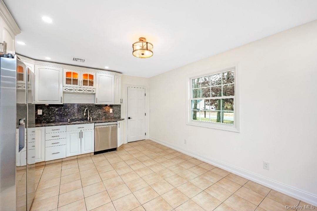 59 Nelson Road Selden, NY 11784 - Photo 13 of 38 Kitchen featuring recessed lighting, appliances with stainless steel finishes, glass insert cabinets, white cabinets, and backsplash
