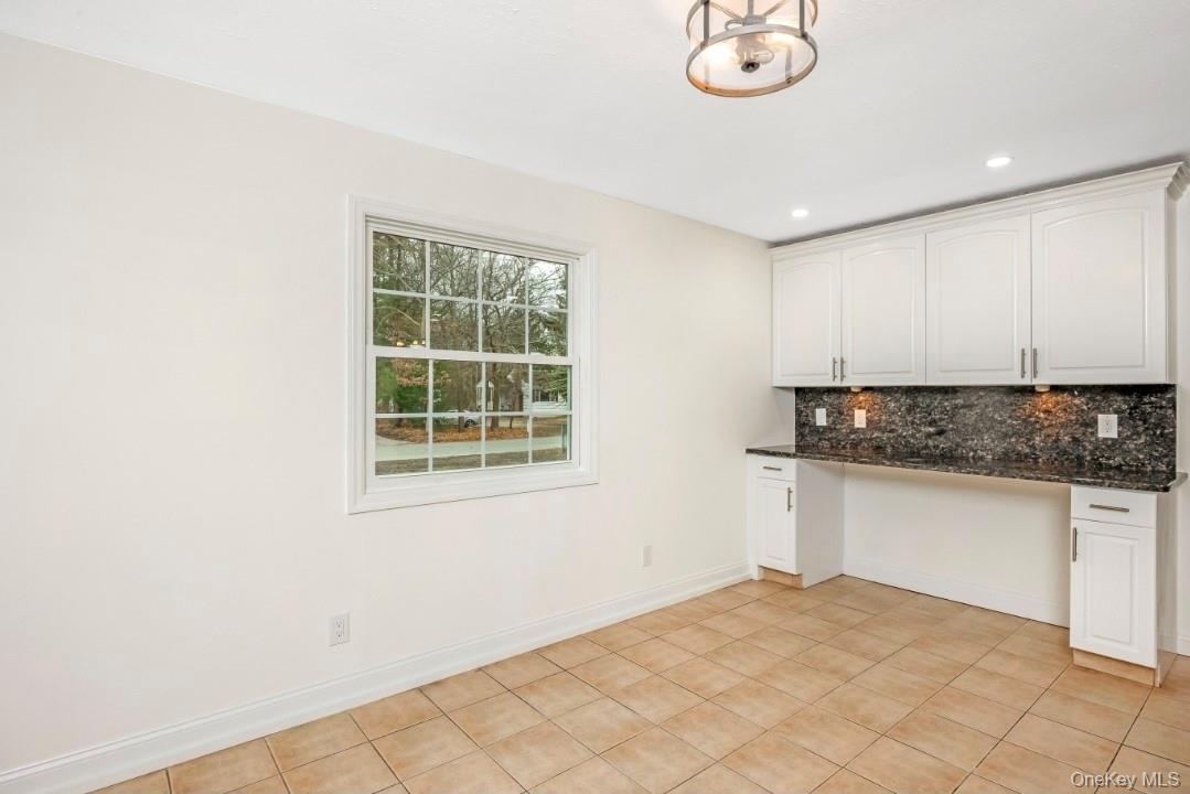 59 Nelson Road Selden, NY 11784 - Photo 15 of 38 Kitchen with built in desk, white cabinetry, tasteful backsplash, dark stone countertops, and recessed lighting