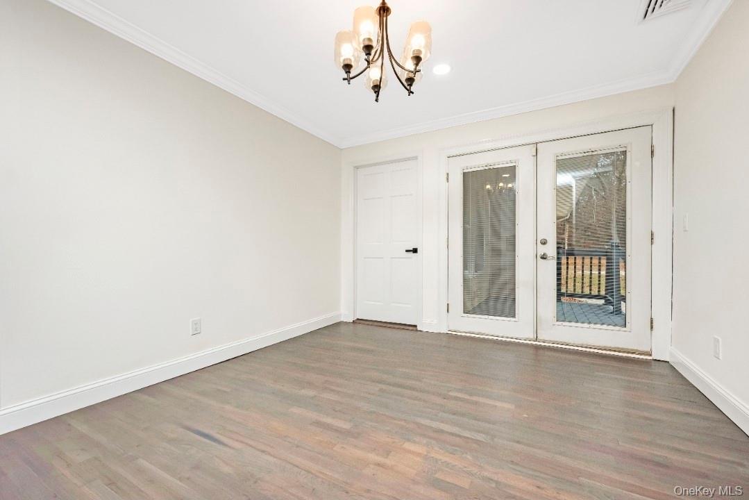 59 Nelson Road Selden, NY 11784 - Photo 16 of 38 Unfurnished room with french doors, a chandelier, wood finished floors, and crown molding