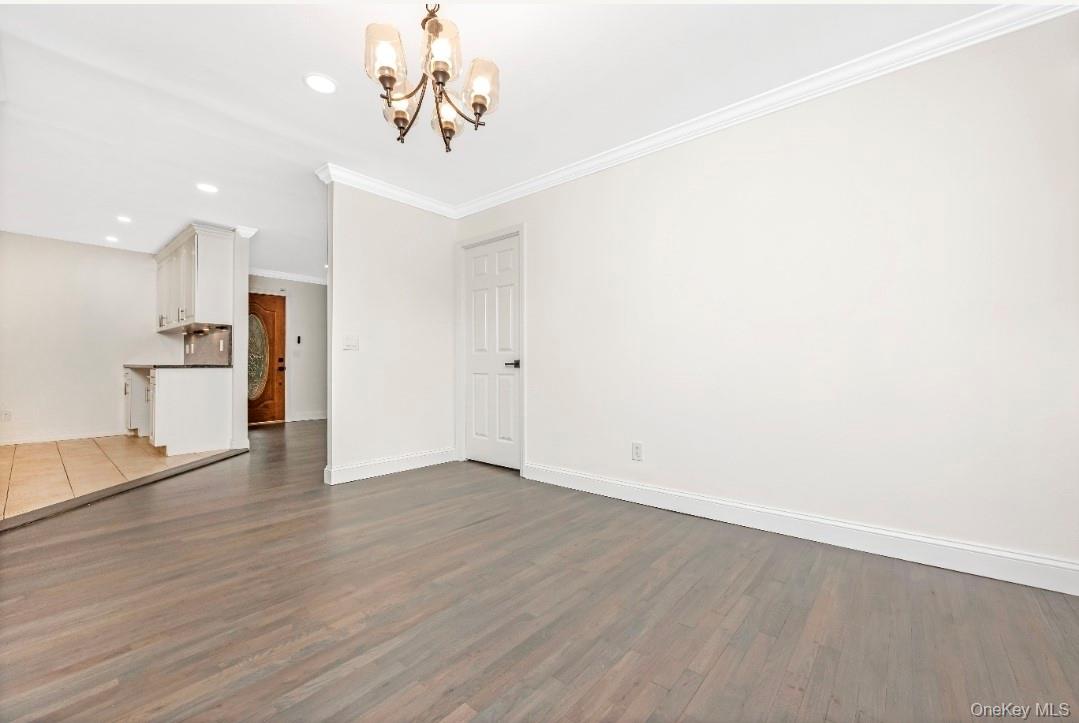 59 Nelson Road Selden, NY 11784 - Photo 17 of 38 Unfurnished living room with a chandelier, crown molding, dark wood-style flooring, and recessed lighting