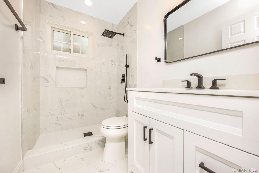 59 Nelson Road Selden, NY 11784 - Photo 18 of 38 Full bathroom with vanity, a marble finish shower, marble look tile flooring, and recessed lighting