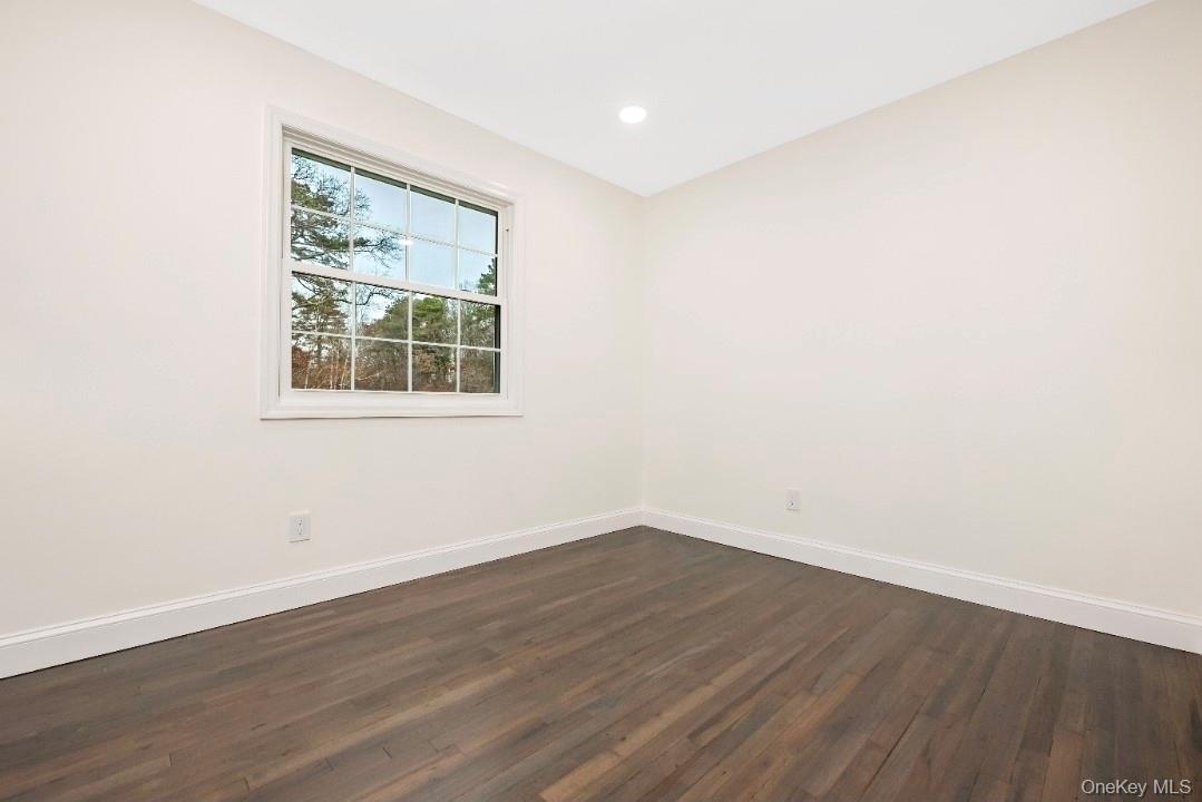 59 Nelson Road Selden, NY 11784 - Photo 19 of 38 Unfurnished room featuring dark wood-style floors and recessed lighting