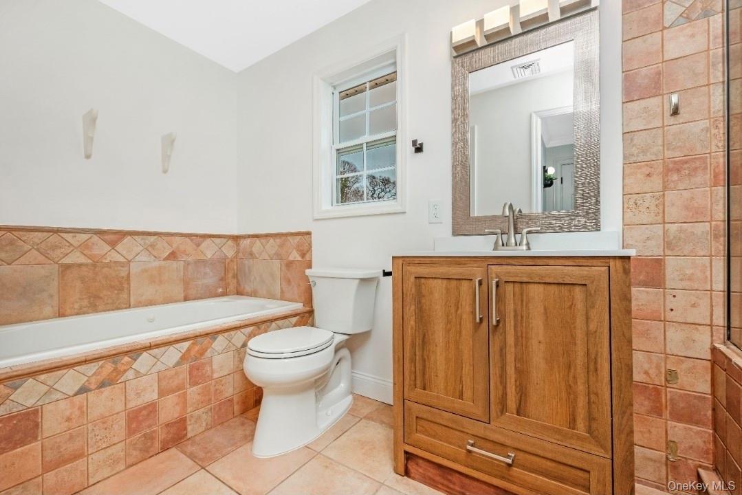 59 Nelson Road Selden, NY 11784 - Photo 25 of 38 Bathroom featuring a bath, vanity, and light tile patterned flooring