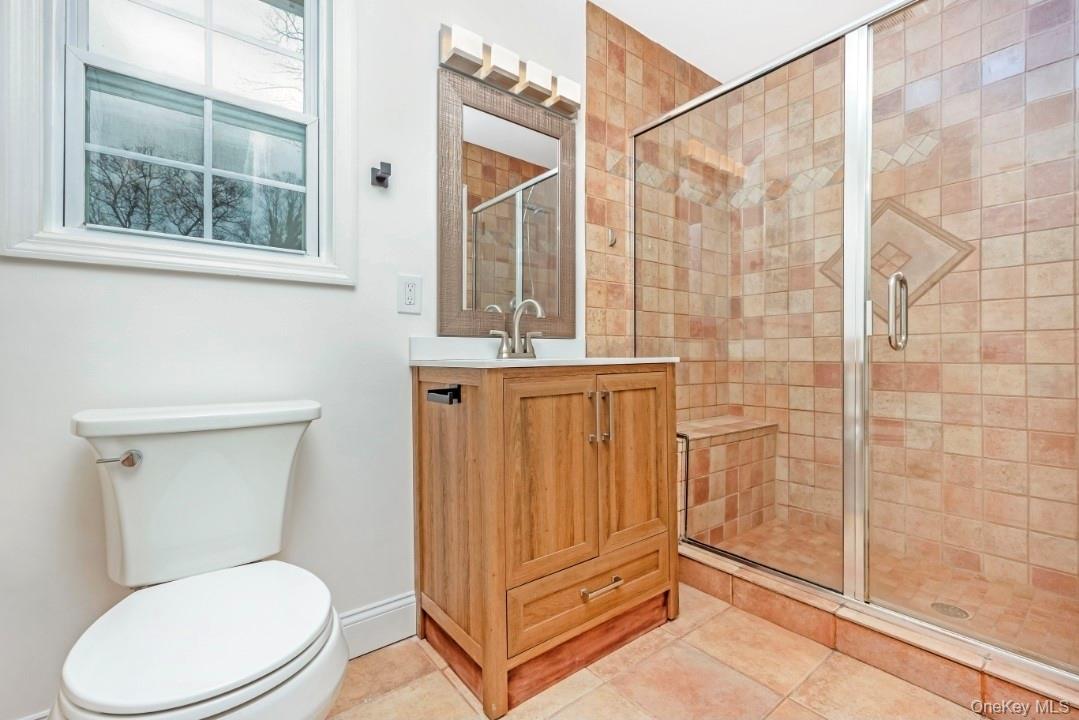 59 Nelson Road Selden, NY 11784 - Photo 28 of 38 Full bathroom featuring a stall shower, vanity, and light tile patterned flooring