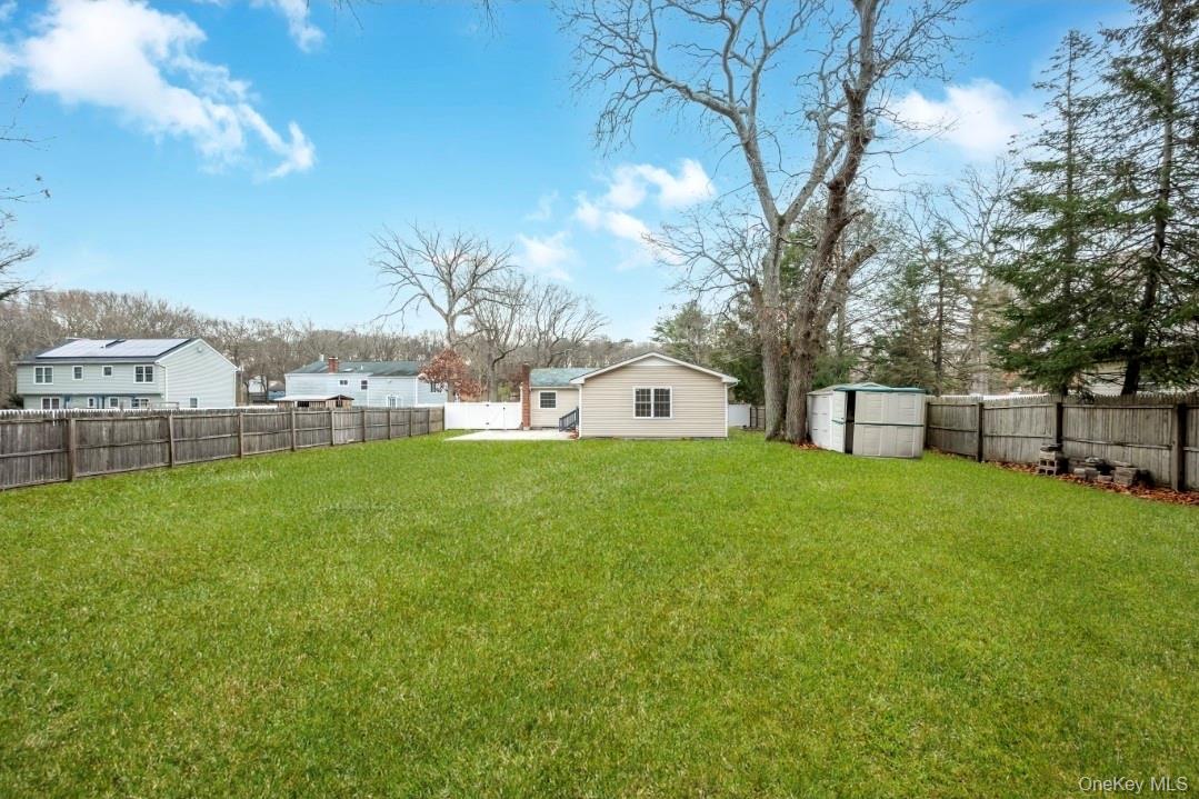 59 Nelson Road Selden, NY 11784 - Photo 7 of 38 Fenced backyard with a shed and a patio area