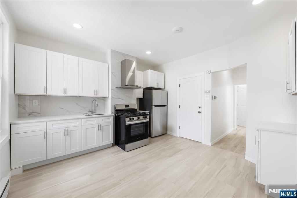 600 67th Street West New York, NJ 07093 - Photo 5 of 12 a kitchen with granite countertop a refrigerator stove top oven and cabinets